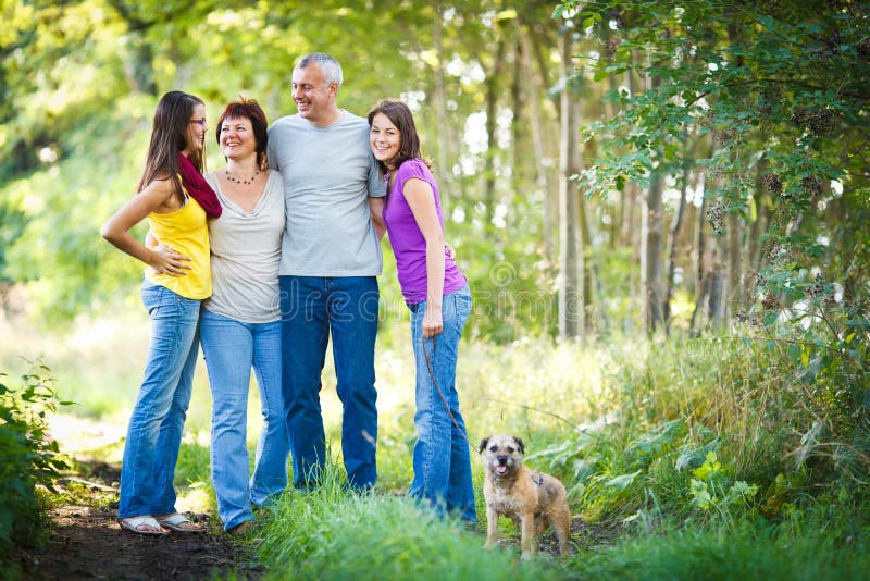 Family of Four with a Cute Dog Outdoors Stock Image Image of male