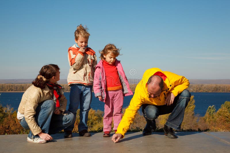 Family from four persons walks in solar autumn day