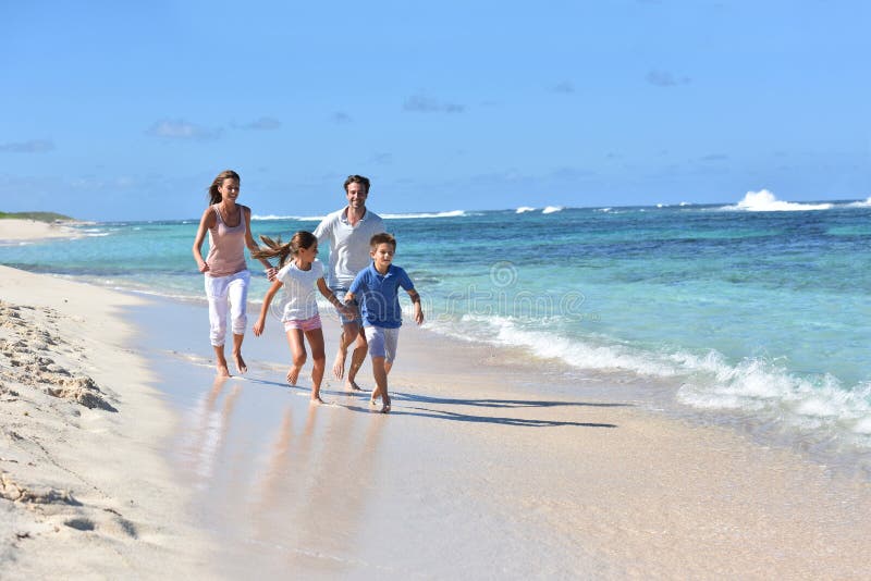 Family of four runinng on the beach in tropics royalty free stock photo Family of four runinng on the beach in tropics royalty free stock photo