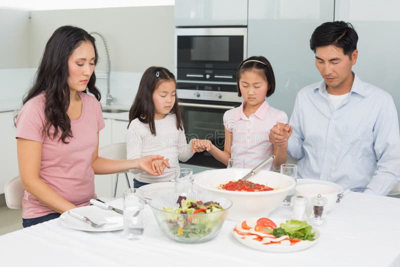 Family of Four Saying Grace before Meal in Kitchen Stock Image - Image ...
