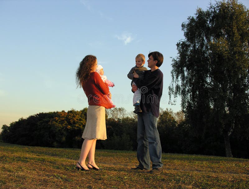 Familia permanecer sobre el atardecer sobre el un árbol.