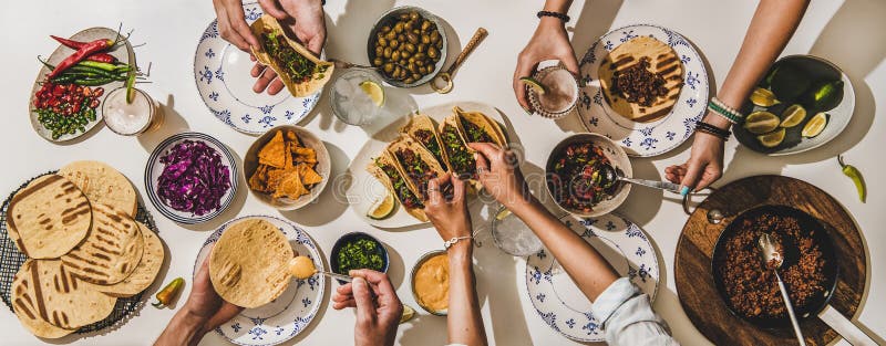 Family or friends having Mexican style Taco dinner with beer