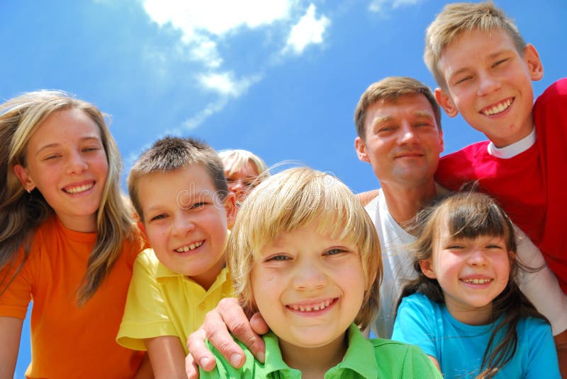 Una famiglia di divertirsi all'aria aperta, l'affollamento insieme e sorridenti nella fotocamera.