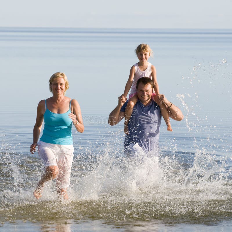 Famiglia felice in esecuzione in mare.