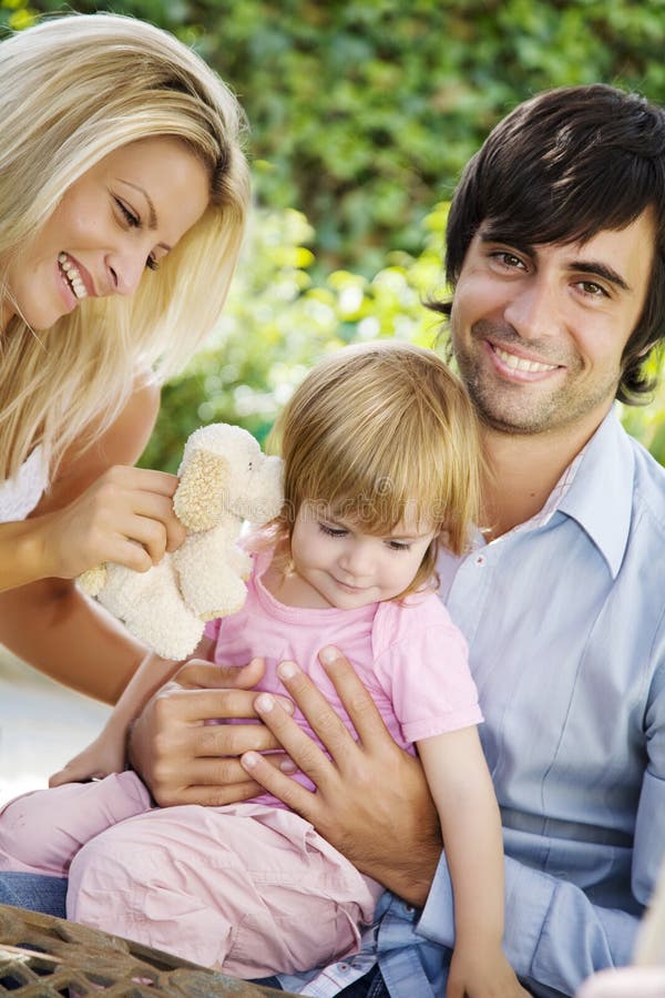 Joven familia en jardín en verano.