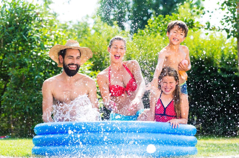 Family in garden pool cooling down splashing water royalty free stock photos Family in garden pool cooling down splashing water royalty free stock photos