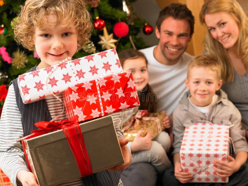 Family with gifts in front of Christmas tree