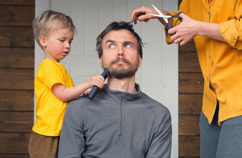 Family haircut at home during quarantine lockdown when closed all hairdressers. Mother cutting hair to father and little child boy