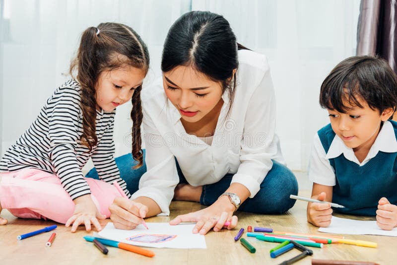 Family happy child kid girl kindergarten paint drawing on peper teacher education with mother mom stock photo Family happy child kid girl kindergarten paint drawing on peper teacher education with mother mom stock photo
