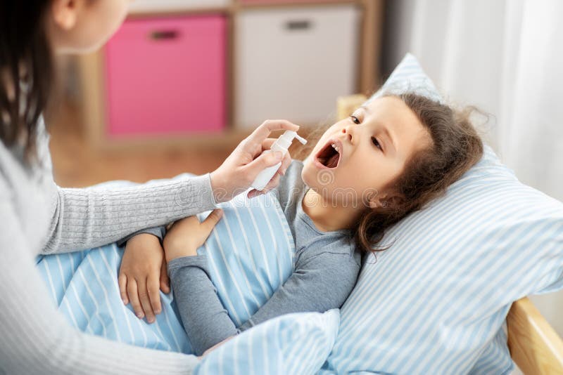 Mother with Oral Spray Treats Sick Little Daughter Stock Ph