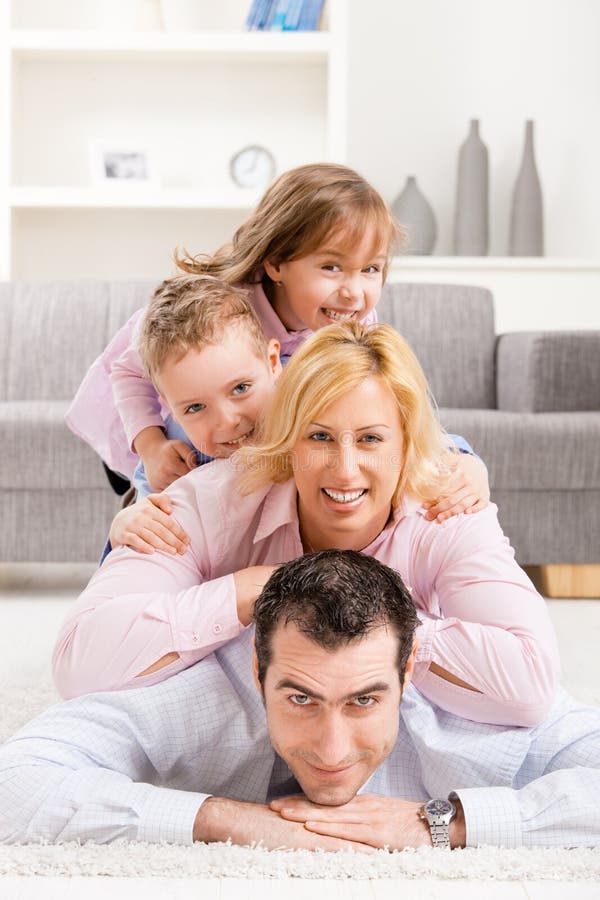 Familia feliz sobre el, acostada sobre el piso en sala de estar.