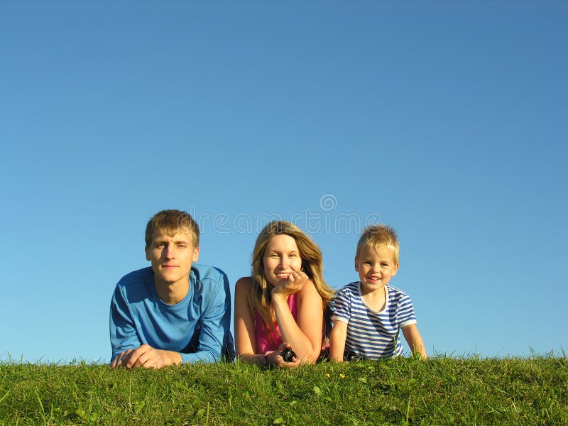 Famiglia sull'erba sotto il cielo blu bugia.