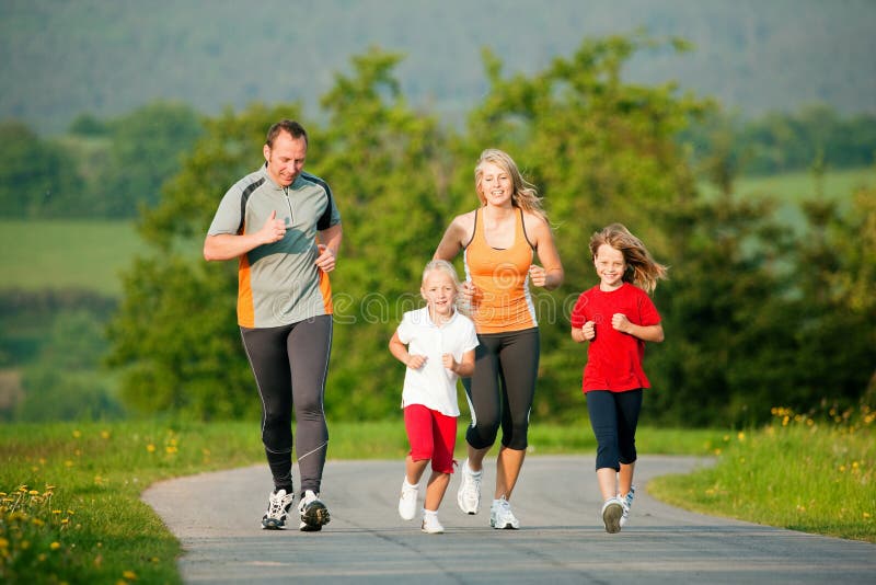 La famiglia che fa dello sport, jogging all'aria aperta con i bambini in uno splendido paesaggio estivo, in il sole del tardo pomeriggio.