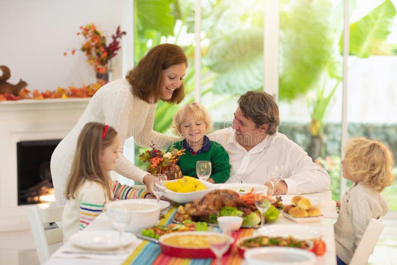 Family with kids at Thanksgiving dinner. Turkey stock image Family with kids at Thanksgiving dinner. Turkey stock image