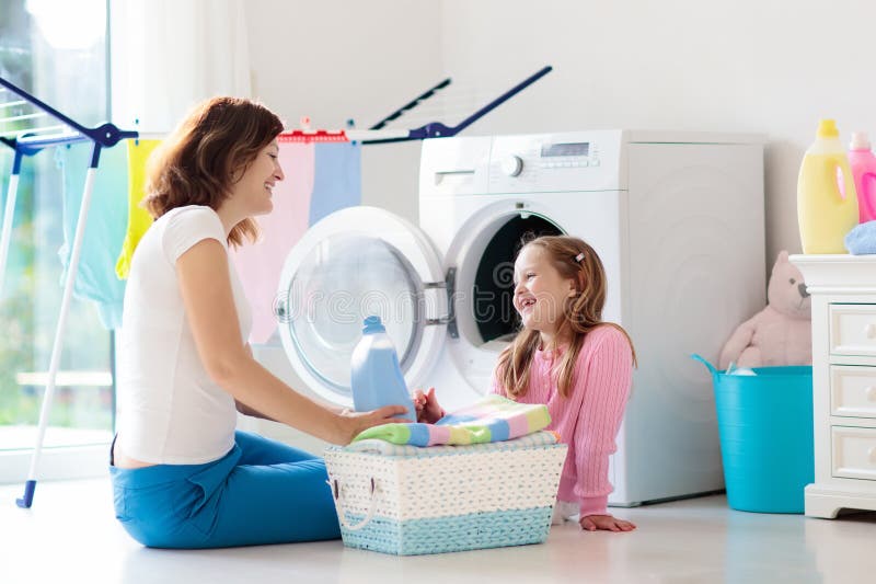 Family in laundry room with washing machine. 