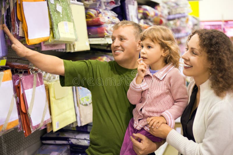 Family with little girl buy bedding in supermarket