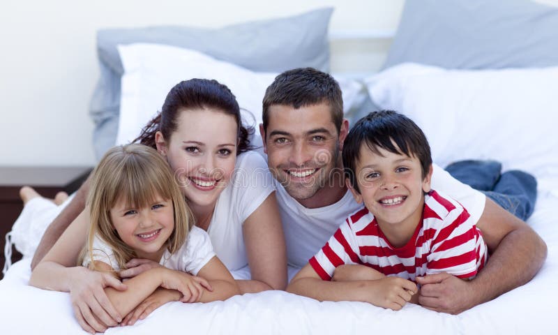 Felice giovane famiglia sdraiato a letto insieme.