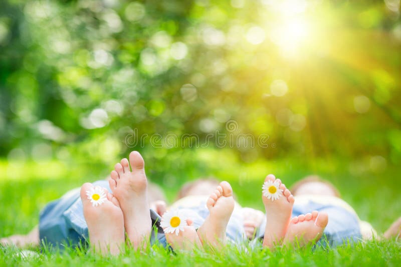 Rodina ležať na tráve vonku na jar parku.