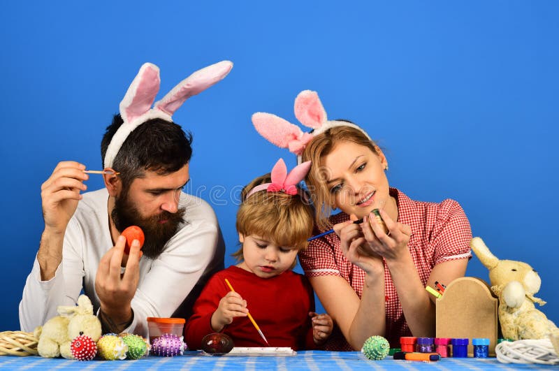 Family members painting eggs on blue background stock photography Family members painting eggs on blue background stock photography