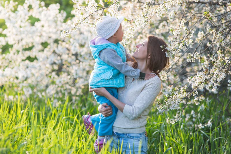 Family mom with daughter woman with child in spring stand and hug