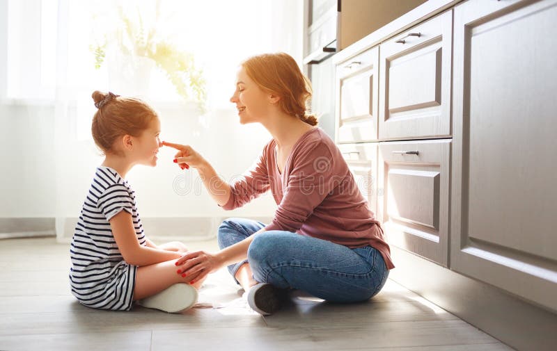 Family mother and child daughter hugging in kitchen on floor royalty free stock photo Family mother and child daughter hugging in kitchen on floor royalty free stock photo