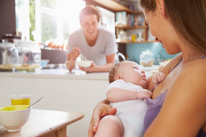 Family With Newborn Baby Daughter At Breakfast Table royalty free stock image