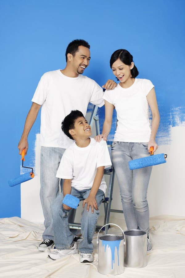 Family with Paint Rollers Getting Ready To Paint the Wall. Conceptual