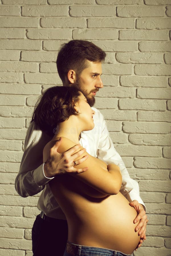 Bearded Man and Pretty Pregnant Woman with Naked Round Belly Stock Image picture