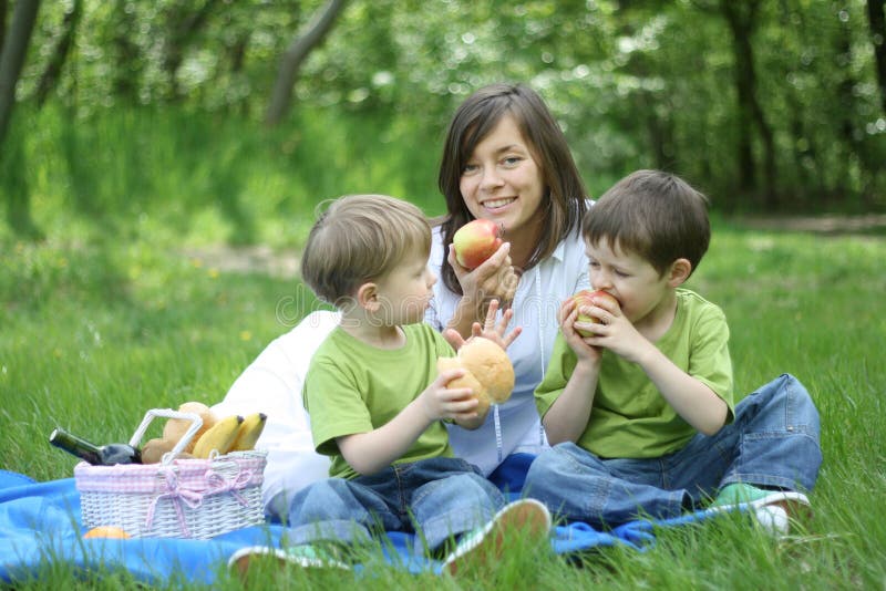 Mother and sons relaxing - family picnic in the forest