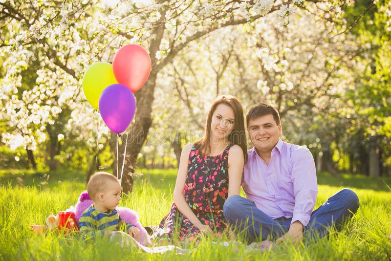 Family picnic. father, mother, child sitting together stock photo Family picnic. father, mother, child sitting together stock photo