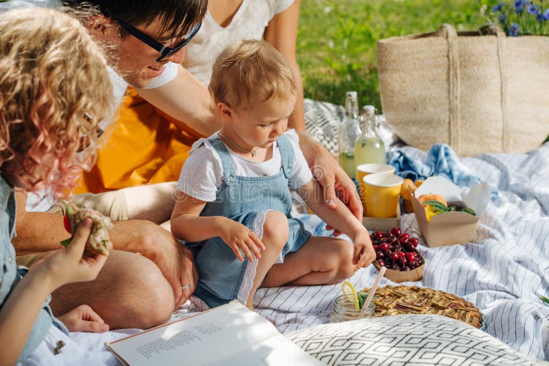 Family Picnic on Grass in the Gardens Under Gentle Shade of Trees Stock ...