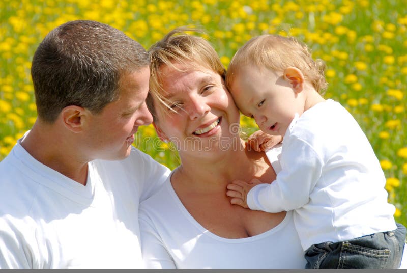 Young Family with Toddler in Dandelion field. Young Family with Toddler in Dandelion field