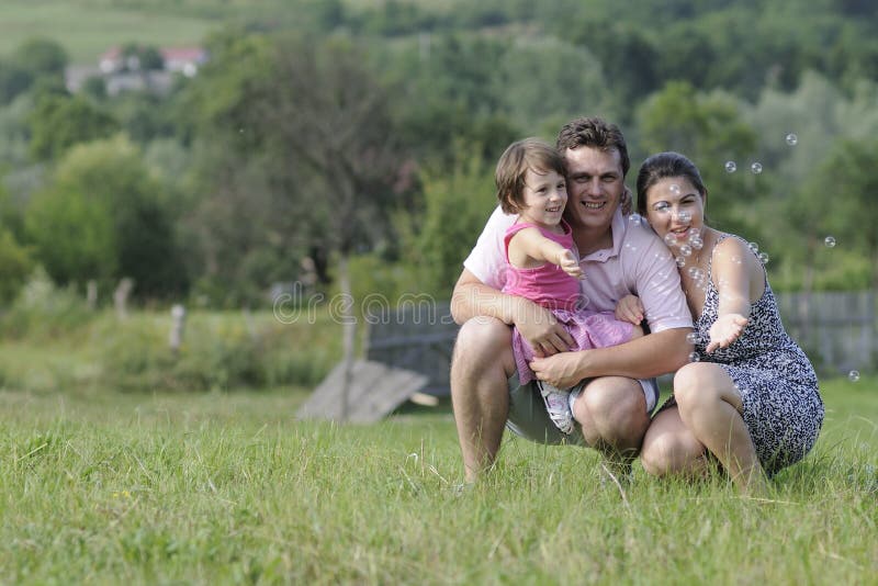 Family playing with bubbles royalty free stock photo