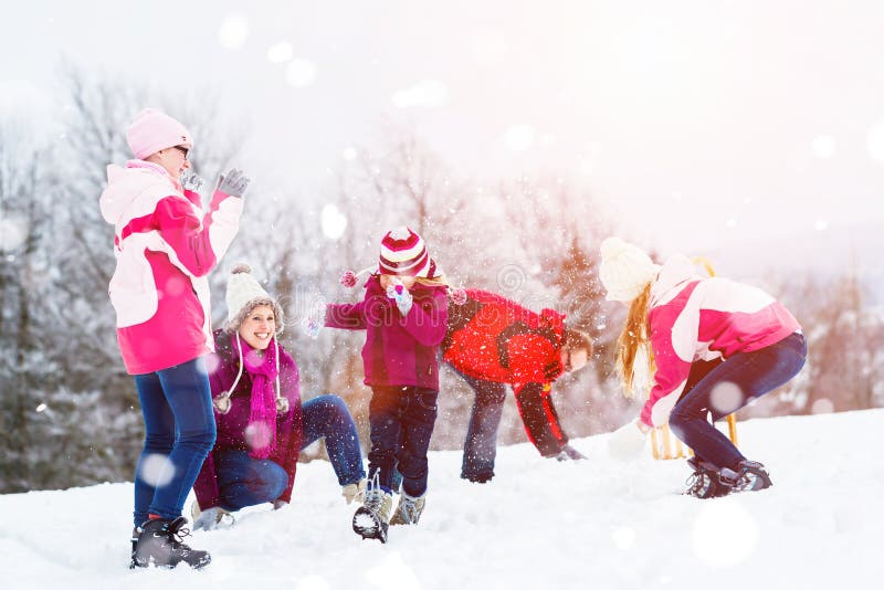 Family Playing In Snow Having Fight With Snowballs