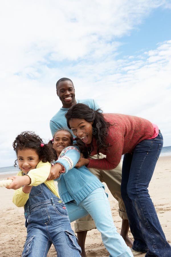 Family playing tug of war on beach royalty free stock photo Family playing tug of war on beach royalty free stock photo