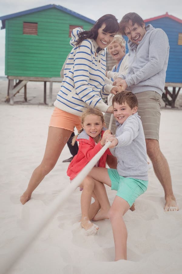 Family playing tug of war at beach