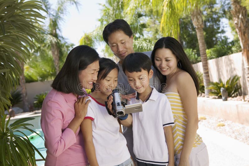 Family by pool Looking at Video Camera Screen