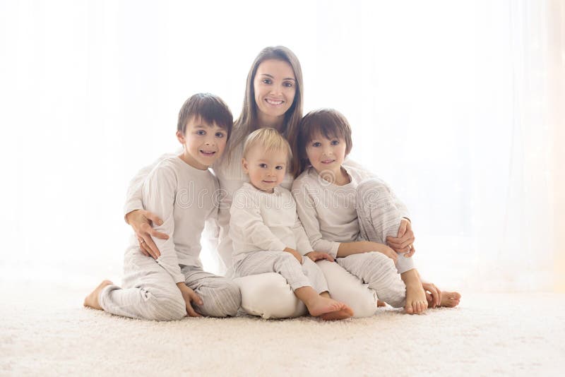 Family portrait of mother and her three boys, isolated on white, back light royalty free stock photography Family portrait of mother and her three boys, isolated on white, back light royalty free stock photography