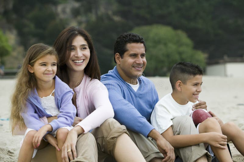Family relaxing on beach stock photography