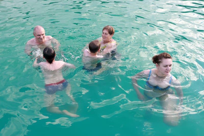 Family relaxing in open pool royalty free stock photo