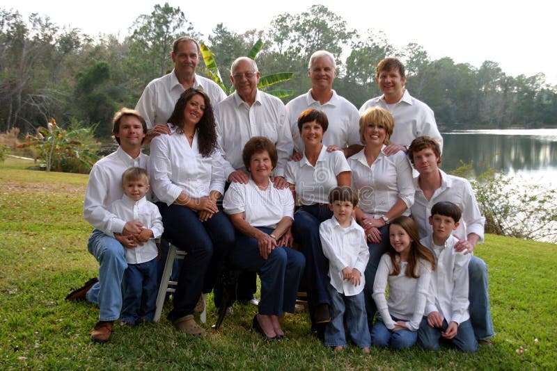 El gran familia de 14 en blanco camisas a mezclilla vaqueros afuera.