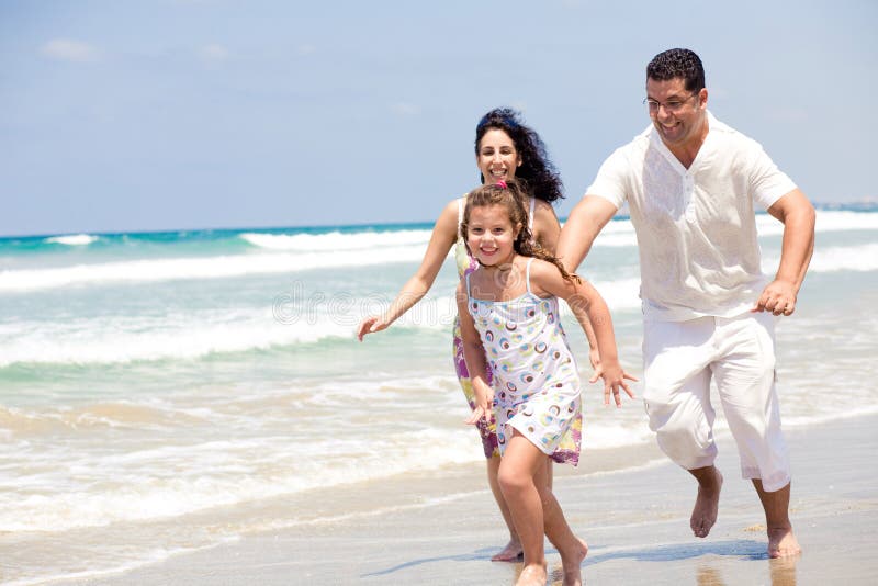 Family running on the beach