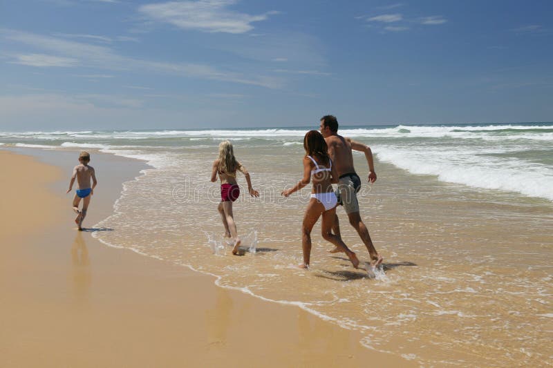 Family running on the beach