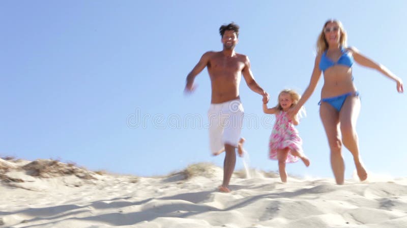Family Running Down Sand Dune Together