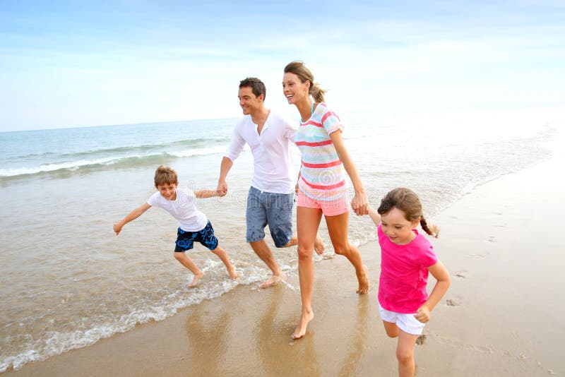 Family running on a sandy beach