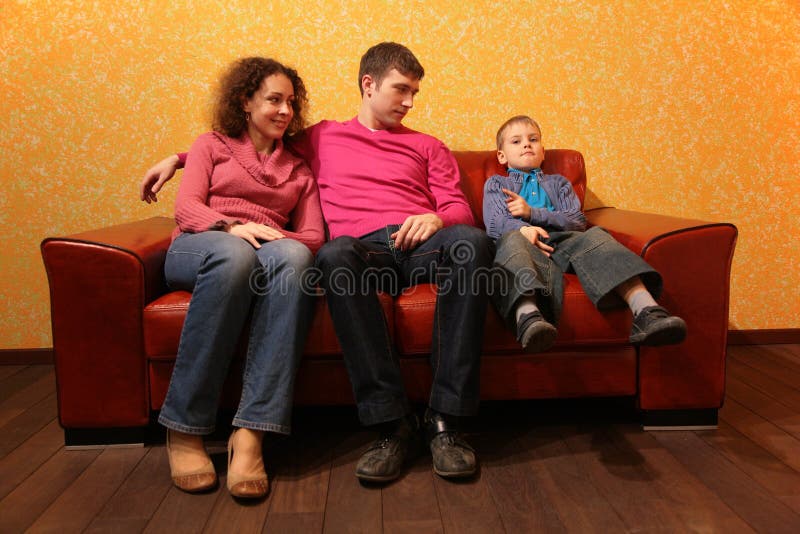 Family seating on red leather sofa