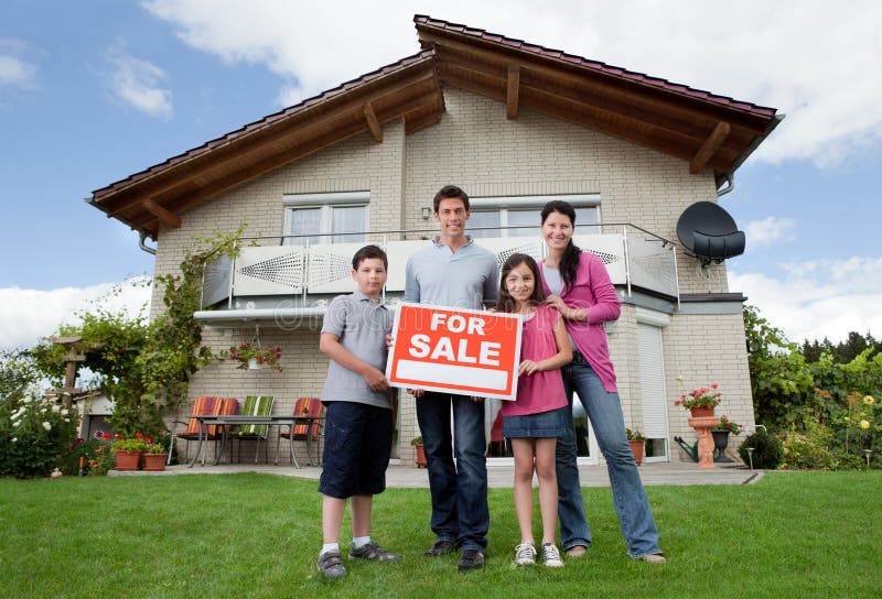 Family selling their home holding for sale sign