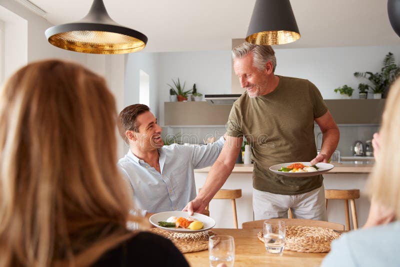 Family With Senior Parents And Adult Offspring Eating Brunch Around Table At Home Together