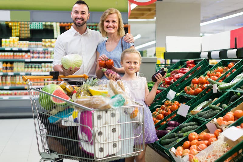 Family shopping various fresh vegetables in supermarket