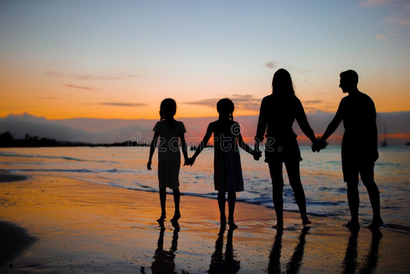 Family silhouette in the sunset at the beach